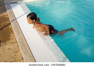 Beautiful Hispanic Boy Playing In An Outdoor Pool