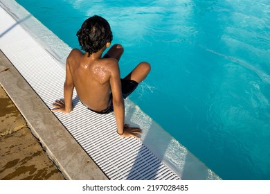 Beautiful Hispanic Boy Playing In An Outdoor Pool