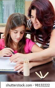 Beautiful Hispanic Girl And Her Young Mother  Studying At Home