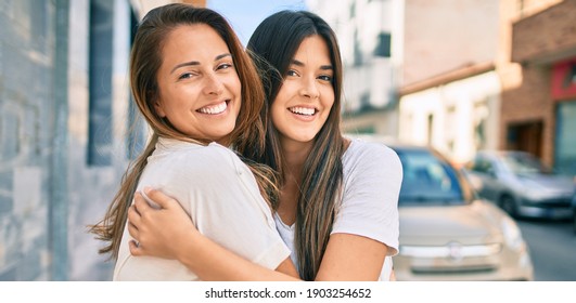 Beautiful hispanic mother and daughter smiling happy standing at the city.
