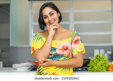 Beautiful hispanic mother or housewife at kitchen indoors at home