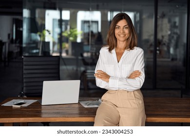 Beautiful hispanic senior business woman with crossed arms smiling at camera. European or latin confident mature good looking middle age leader female businesswoman on office background, copy space. - Shutterstock ID 2343004253