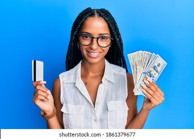 Beautiful hispanic woman holding dollars and credit card smiling with a happy and cool smile on face. showing teeth. 