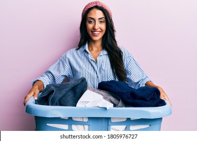 Beautiful Hispanic Woman Holding Laundry Basket Smiling And Laughing Hard Out Loud Because Funny Crazy Joke. 