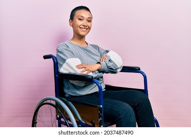 Beautiful hispanic woman with short hair sitting on wheelchair happy face smiling with crossed arms looking at the camera. positive person.  - Powered by Shutterstock