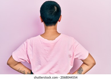 Beautiful Hispanic Woman With Short Hair Wearing Casual Pink T Shirt Standing Backwards Looking Away With Arms On Body 