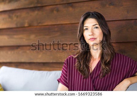 Beautiful Hispanic woman sitting on a sofa