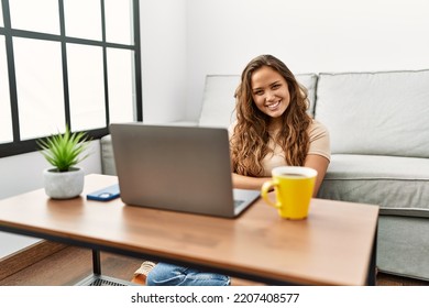 Beautiful Hispanic Woman Using Computer Laptop At Home Happy Face Smiling With Crossed Arms Looking At The Camera. Positive Person. 