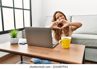 Beautiful Hispanic Woman Using Computer Laptop At Home Smiling In Love Showing Heart Symbol And Shape With Hands. Romantic Concept. 