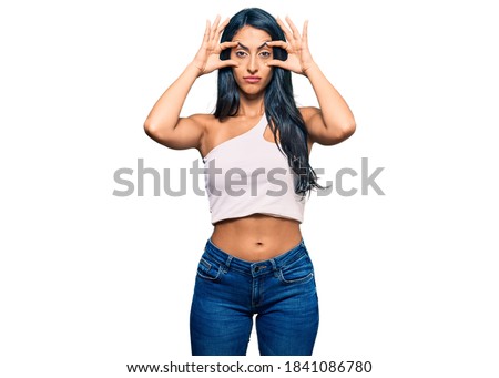 Beautiful hispanic woman wearing casual clothes trying to open eyes with fingers, sleepy and tired for morning fatigue 