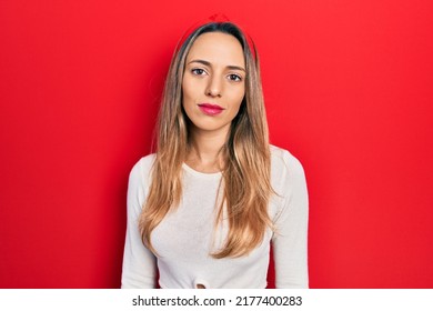 Beautiful Hispanic Woman Wearing Red Diadem Relaxed With Serious Expression On Face. Simple And Natural Looking At The Camera. 