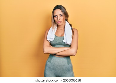 Beautiful Hispanic Woman Wearing Sportswear And Towel Skeptic And Nervous, Disapproving Expression On Face With Crossed Arms. Negative Person. 