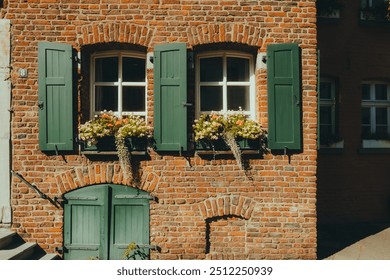 Beautiful historic German brick house, windows with shutters and flowers. European architecture - Powered by Shutterstock