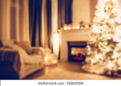 Beautiful holiday decorated room with Christmas tree armchair and fireplace at night. Led lighting, cozy home scene. Nobody there. Out of focus shot for holiday background. - Powered by Shutterstock