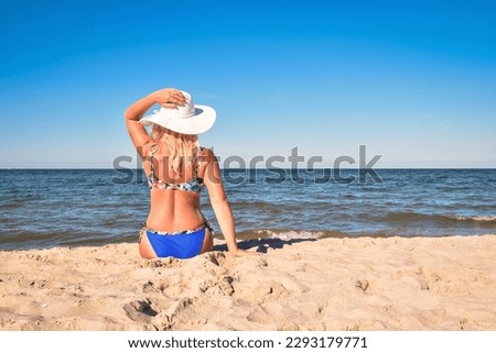 
Beautiful holiday sunny concept with a woman by the sea. Blond-haired girl on the beach in Jastarnia, Poland.