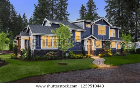 Beautiful Home Exterior at Twilight: New House with Beautiful Yard and Landscaping with Glowing Interior Lights