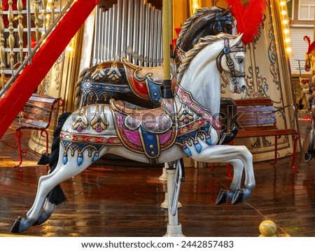 beautiful horses on rotating carousel in the amusement park in the evening