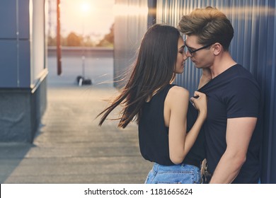beautiful hot interracial couple hugging and going to kiss on roof with sunlight