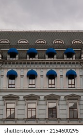 Beautiful House With Blue Fabric Visors On The Windows. Renovated Old House. Beautiful Architecture. Windows And Roof. Elegant Building With Loft Windows