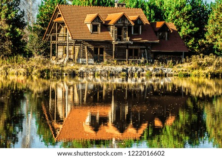 Beautiful house reflected in the lake. Autumn landscape.