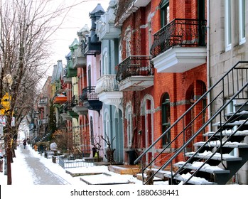 Beautiful houses of old historical Montreal neighborhood Plateau Mont Royal in winter season, bright painted doors.