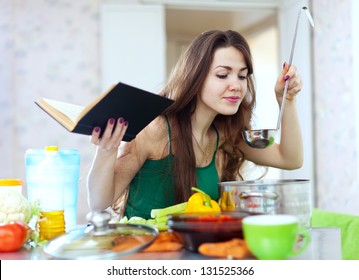  Beautiful Housewife Cooking With Ladle And Cookbook In  Kitchen