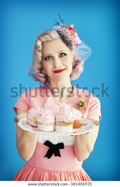 Beautiful, housewife &\
Mom dressed in fabulous vintage attire, holding a plate of homemade\
cupcakes.