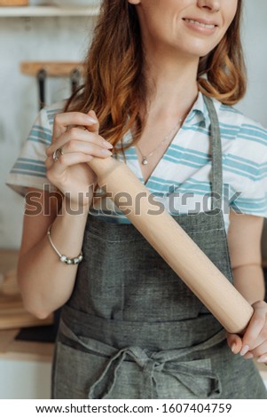 Beautiful housewife in a stylish apron cooks in a cozy kitchen. Close-up