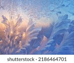 Beautiful ice pattern and sunlight close up on window glass early in the morning, natural winter background