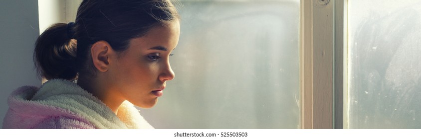 Beautiful Ill Sad Girl In Night Gown Looking Through Hospital Window.