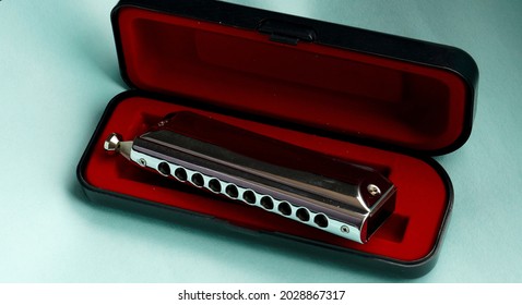 Beautiful image of harmonica with its box.                             