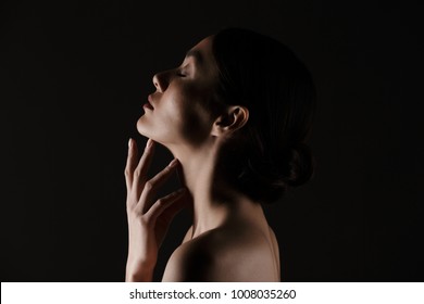 Beautiful Image In Profile Of Half-naked Gentle Woman Posing On Camera With Closed Eyes Isolated Over Black Background