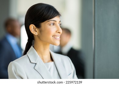 beautiful indian businesswoman looking outside office window - Shutterstock ID 225972139