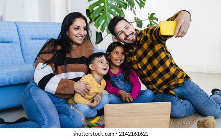 Beautiful Indian Family Father And Mother With Two Children Taking Selfie At Home