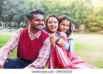 Schöne indische Familie umarmt sich während des Picknick im Park