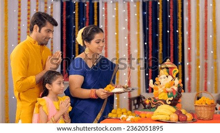 Beautiful Indian family worshipping Lord Ganesha with pooja ki thali - festival celebration, religious event, praying to god. Hindu rituals and customs - Indian stock footage of worshipping Hindu G...