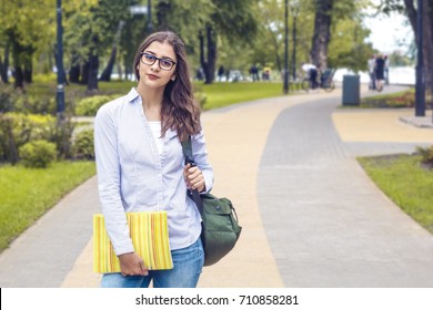Beautiful Indian Girl, Student, With Books Near College. Female Mixed Race Stands At The Campus.