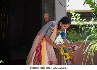 Beautiful Indian Married Woman Decorating Her House With Marigold Flowers Garland During Diwali Festival. House Warming, Party, Pooja, Marriage, Wedding, Arrangement, Preparation, Traditional, Fresh.