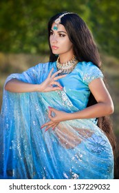 beautiful indian woman bellydancer dancing bollywood dance in sari outdoors. Brunette indian beauty girl artist dancing arabian dance or bellydance with bridal makeup and jewelry. bollywood dancer