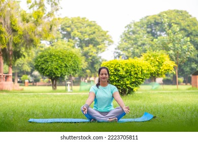 Beautiful indian woman doing yoga exercise in the park. - Powered by Shutterstock