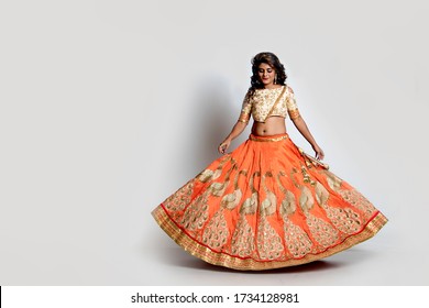 Beautiful Indian Woman In A Golden And Orange Lehenga Choli