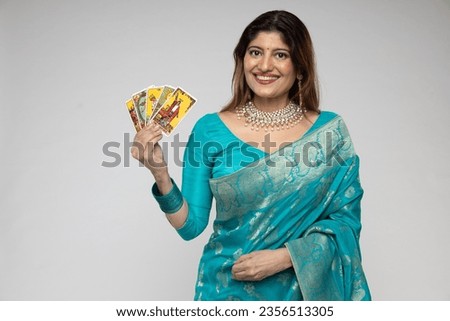 Beautiful Indian woman hands showing Taro Card Reader wearing traditional blue saree isolated on white background. during taro card reader concept theme.