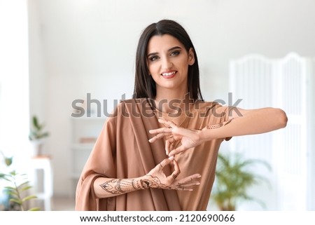 Beautiful Indian woman with henna tattoo at home