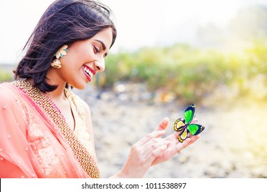 Beautiful indian woman holding butterfly in her hand