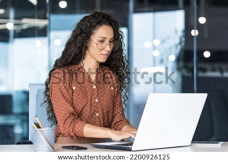 Beautiful indian woman programmer web developer focused and confident working on laptop writing code programming business woman worker in modern office working in casual clothes