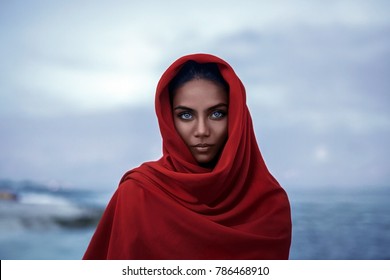 Beautiful indian woman with red paranja and blue eyes in the twilight