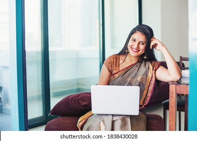 Beautiful Indian Young Woman In A Saree Using Her Laptop, Working From Home