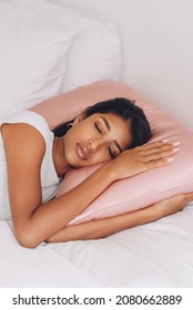 Beautiful Indonesian girl lying on a pink pillow with a silk pillowcase. - Shutterstock ID 2080662889