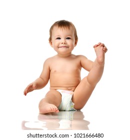 Beautiful Infant Baby Girl Toddler Sitting In Diaper And Hold One Leg Isolated On White Background