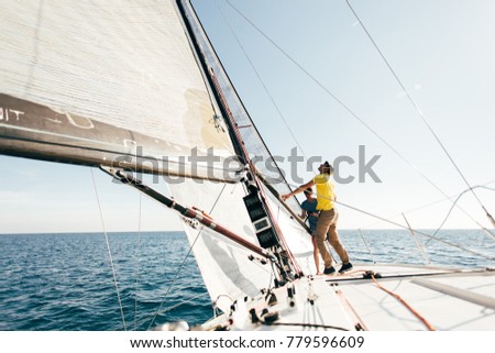Beautiful inspiring shot of action adventure of sailor or captain on yacht or sailboat attaching big mainsail or spinnaker with ropes on deck of epic boat, sunny summer adventure lifestyle